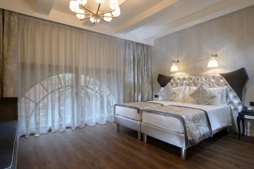 a bedroom with a large bed and a chandelier at Palazzo Veneziano - Venice Collection in Venice