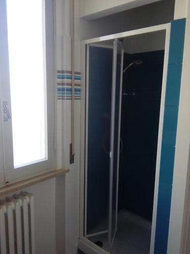 a shower with a glass door in a bathroom at Gardenia Guest House in Forlì