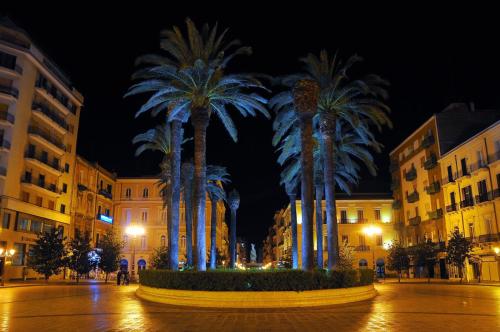 a group of palm trees in a city at night at Room n.22 in Taranto