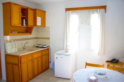 a kitchen with a white refrigerator and a table at Toloman Hotel Bitez Beach in Bitez
