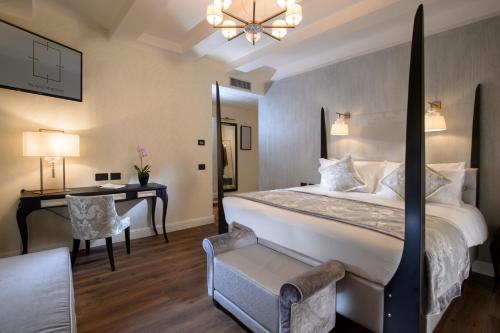 a bedroom with a large bed and a desk and a table at Palazzo Veneziano - Venice Collection in Venice