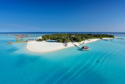 an island in the ocean with a boat on it at Velassaru Maldives in South Male Atoll