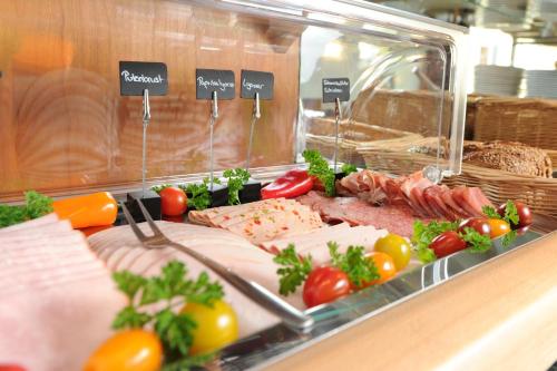 a buffet with meats and vegetables on a counter at Central-Classic Hotel in Stuttgart