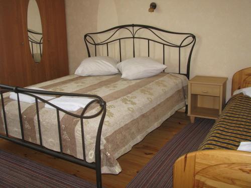a bedroom with a bed with a black frame and white pillows at Piligrimo Užeiga in Kadarės
