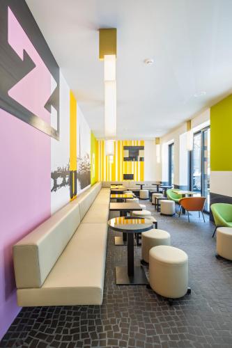 a lobby with a waiting area with tables and chairs at Züri by Fassbind in Zürich