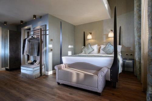 a bedroom with a large bed and a chair at Palazzo Veneziano - Venice Collection in Venice