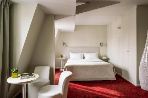 um quarto com uma cama, uma mesa e uma cadeira em Le Quartier Bercy-Square em Paris