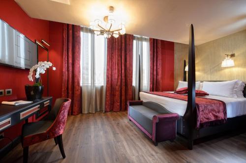 a hotel room with a bed and a desk at Palazzo Veneziano - Venice Collection in Venice