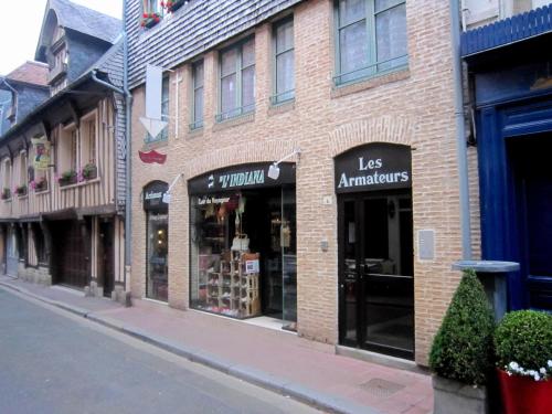 a store on the side of a brick building at Cosy Apartment in Honfleur with a Private Garden in Honfleur