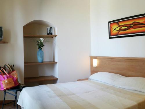 ArceviaにあるSerene Holiday Home in Piticchio with pool and scenic viewsのベッドルーム1室(ベッド1台付)が備わります。壁には絵画が飾られています。