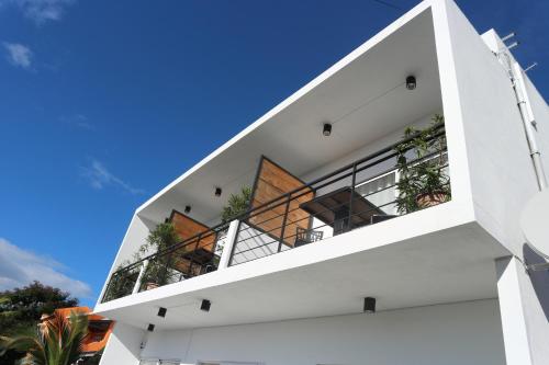 a white house with balconies against a blue sky at Arkenstone Studios in La Gaulette