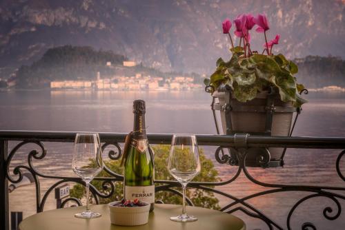 a bottle of wine sitting on a table with two wine glasses at Royal Cadenabbia in Griante Cadenabbia