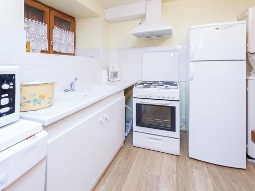 una cucina bianca con elettrodomestici bianchi e pavimenti in legno di Calvinet Countryside Escape a Calvinet
