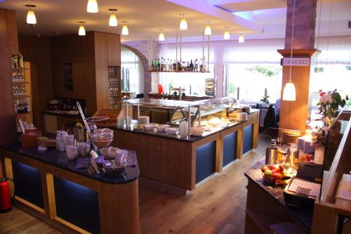 a restaurant with a counter with food on it at Hotel Seeterrassen in Laboe