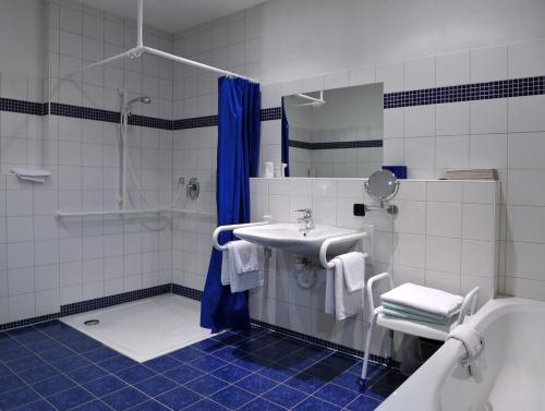 a bathroom with a sink and a shower and a tub at Hotel Grüner Baum in Pommersfelden