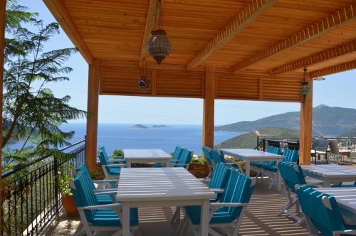 a deck with tables and chairs and the ocean at The Mediteran Hotel in Kalkan