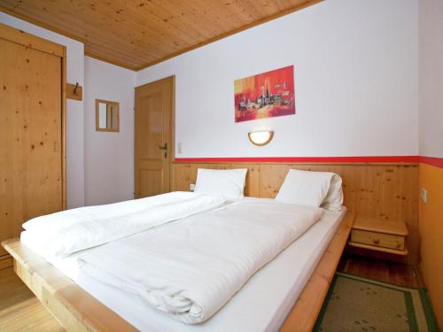 a large white bed in a room with avertisementatronatronstrationstration at Plush Apartment in Altenmarkt im Pongau near Ski Area in Altenmarkt im Pongau