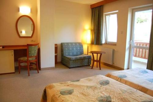 a hotel room with two beds and a chair and a desk at Hotel Seasons in Tryavna