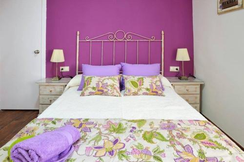 1 dormitorio con 1 cama con paredes de color púrpura y almohadas de color púrpura en De Patios, en Córdoba