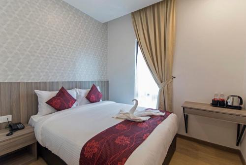 a hotel room with a bed with a swan on it at Signature International Hotel China Town in Kuala Lumpur