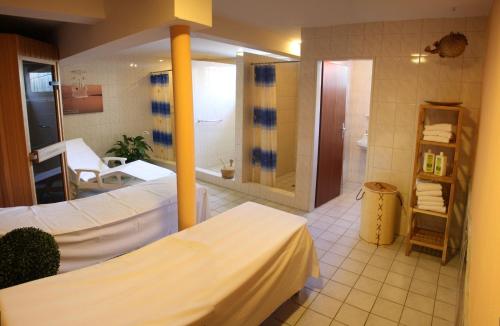 a large bathroom with two beds and a shower at Hotel Seeterrassen in Laboe