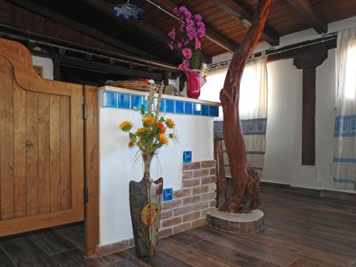 a vase with flowers in it next to a tree at Agriturismo Codula Fuili in Cala Gonone