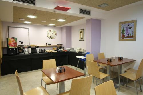 a restaurant with two tables and chairs and a counter at Hotel Alda Entrearcos in Burgos