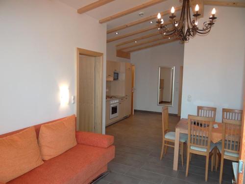 a living room and dining room with a couch and a table at Pension Noella in Sankt Johann in Tirol