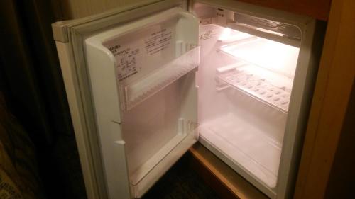 an empty refrigerator with its door open in a room at Hotel Grand Terrace Chitose in Chitose