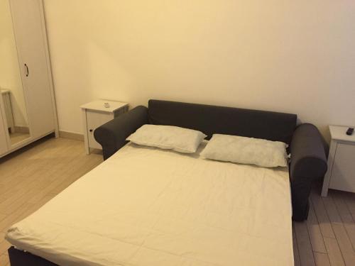 1 cama con 2 almohadas en una habitación en Monolocale Minzoni en Porto Azzurro