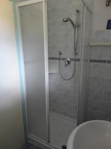 een douche met een glazen deur in de badkamer bij casa bellavista in Marina di Campo
