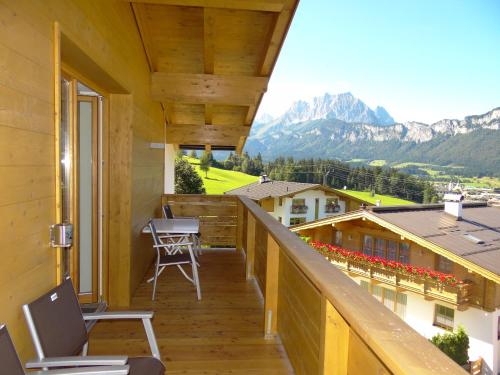 a balcony with chairs and a view of mountains at Pension Noella in Sankt Johann in Tirol