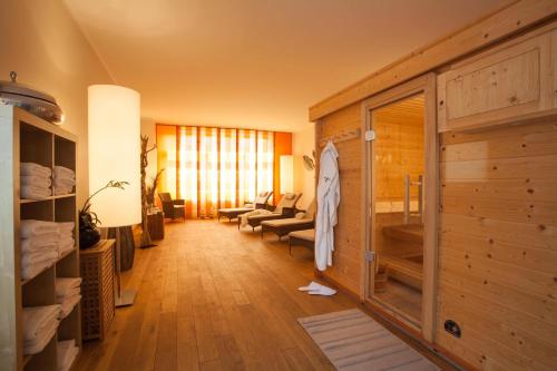 ein Zimmer mit einem Wohnzimmer mit einer Holzwand in der Unterkunft Hotel Barnimer Hof in Wandlitz