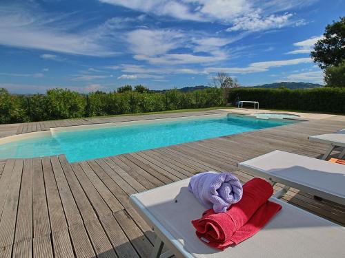 un paio di asciugamani seduti su un tavolo accanto alla piscina di Luxurious Cottage with Swimming Pool in Montelabbate a Montelabbate