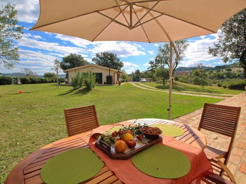 - une table avec un plateau de fruits et un parasol dans l'établissement Luxurious Cottage with Swimming Pool in Montelabbate, à Montelabbate