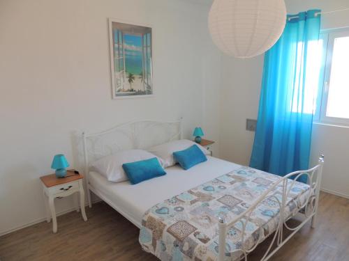 a bedroom with a bed with blue curtains and a window at Apartments Nada in Betina