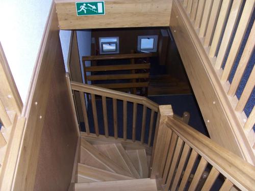 a wooden stairway with a green sign on it at Penzion Chanos in Stříbro
