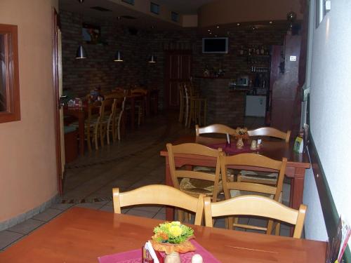 a dining room with wooden tables and chairs and a room with a hallway at Penzion Chanos in Stříbro