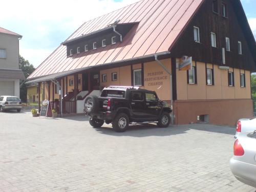 a black truck parked in front of a building at Penzion Chanos in Stříbro