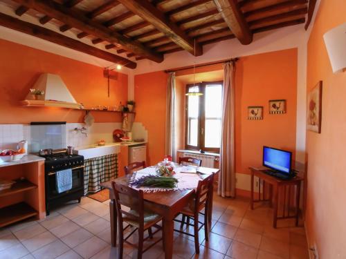 a kitchen with a table and a kitchen with orange walls at Apartment in Montalto near Lake and Pool in Montalto di Castro