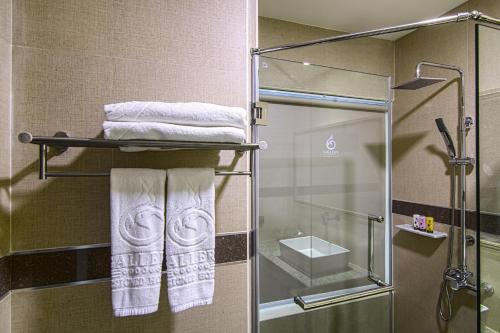 a bathroom with a glass shower stall with towels at Gallery Design - SHA Extra Plus in Si Sa Ket