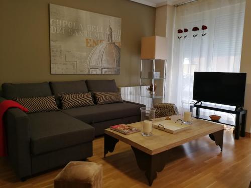 a living room with a couch and a coffee table at 18 Torres El Pilar in Zaragoza