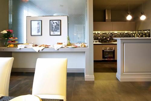 a kitchen with a counter and chairs in a room at Vittoriano Luxury Suites in Rome