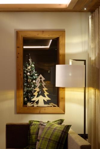 a christmas tree in a mirror in a living room at Ravelli Sporting in Mezzana