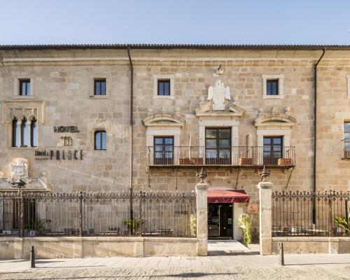 a large stone building with a fence in front of it at Hotel Ilunion Mérida Palace in Merida