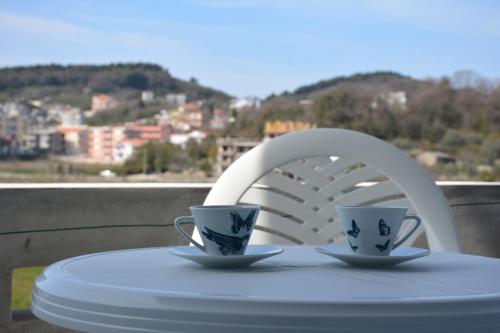 two coffee cups on a table with a chair at Apartments Flamida in Ulcinj
