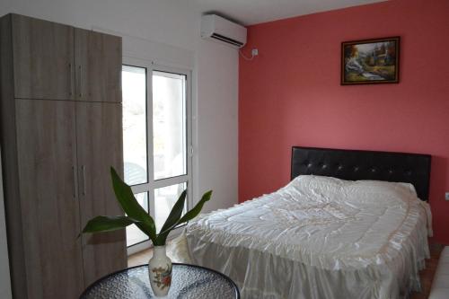 a bedroom with a bed and a vase on a table at Apartments Flamida in Ulcinj