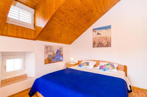 a bedroom with a blue bed and a wooden ceiling at Apartments Peppino - Old Town in Dubrovnik