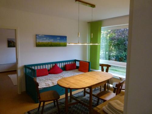 a room with a table and a bed with red pillows at Ferienwohnung Garten Eben in Rullstorf