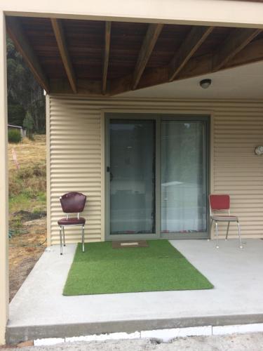 two chairs sitting on a patio with grass at Scout Hall in National Park